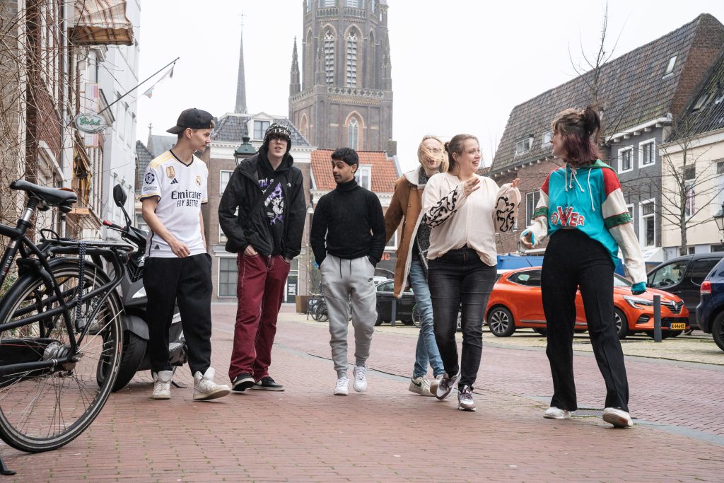 Foto van groep vrolijke jongeren op straat