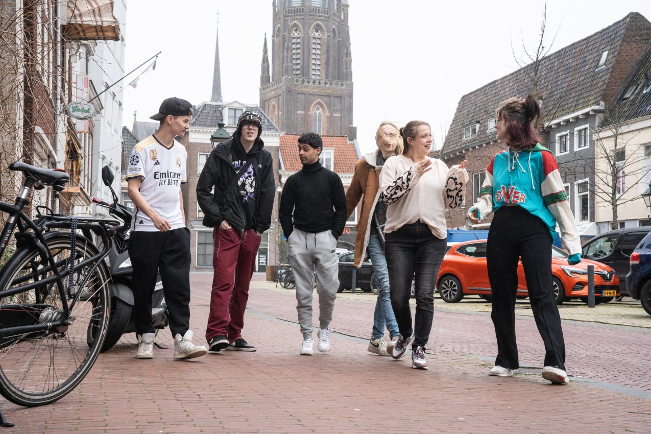 Foto van groep vrolijke jongeren op straat